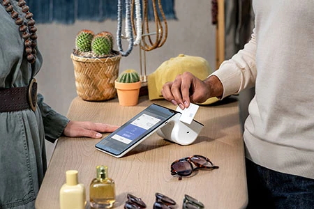 Une femme utilisant le système de conversion multidevise (Multi-Currency Conversion, MMC) d’Elavon