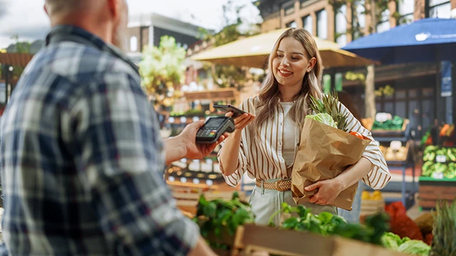 Une femme payant son épicerie avec une carte de crédit